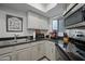 A kitchen featuring stainless steel appliances, light grey cabinetry, and black granite countertops at 985 N Granite Reef Rd # 127, Scottsdale, AZ 85257
