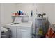 Functional laundry room with modern washer and dryer, plus water heater and storage shelf at 985 N Granite Reef Rd # 127, Scottsdale, AZ 85257