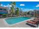 Community pool surrounded by lounge chairs, patio tables and umbrellas at 985 N Granite Reef Rd # 127, Scottsdale, AZ 85257
