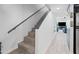 Clean and well-lit staircase with wood-look tile and a modern handrail leading to the next level at 985 N Granite Reef Rd # 127, Scottsdale, AZ 85257