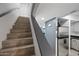 A staircase with wood-like tile steps, complemented by gray walls and a modern stainless steel refrigerator at 985 N Granite Reef Rd # 127, Scottsdale, AZ 85257