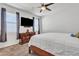 Neutral Primary bedroom showcases a ceiling fan, TV, wood dresser, and natural light from two large windows at 10320 E Lupine Ln, Florence, AZ 85132