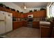 Traditional style kitchen with wood cabinets, tile countertops, and stainless steel appliances at 10322 W Reade Ave, Glendale, AZ 85307