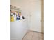 A bright laundry room featuring a white washer/dryer, a storage shelf and a tiled floor at 10322 W Reade Ave, Glendale, AZ 85307