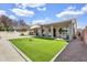 This backyard features an expanse of lush artificial turf, bordered by neutral gravel and a covered patio at 108 N Pioneer St, Gilbert, AZ 85233