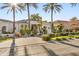 Elegant white home showcasing lush landscaping, stone driveway, and mature palm trees at 10800 E Cactus Rd # 38, Scottsdale, AZ 85259