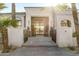 Grand entrance with modern iron doors, stone walkway, and manicured potted plants at 10800 E Cactus Rd # 38, Scottsdale, AZ 85259