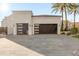 A modern three-car garage with sleek black doors and a spacious stone driveway at 10800 E Cactus Rd # 38, Scottsdale, AZ 85259