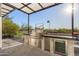 The outdoor kitchen features a built-in stainless grill, countertop space, and convenient under-counter refrigerator at 10800 E Cactus Rd # 38, Scottsdale, AZ 85259