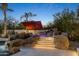 Picturesque pool featuring a rock waterfall with ambient stair lighting and surrounding palm trees at 10800 E Cactus Rd # 38, Scottsdale, AZ 85259