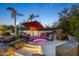 Backyard pool showcasing a rock waterfall with vivid lighting and desert landscaping at 10800 E Cactus Rd # 38, Scottsdale, AZ 85259