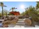 Inviting rock waterfall pool feature with stairs and an orange umbrella providing shade at 10800 E Cactus Rd # 38, Scottsdale, AZ 85259