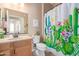 Well-lit bathroom showcases a decorative shower curtain, vanity with a faux marble countertop and mirror at 10960 E Monte Ave # 242, Mesa, AZ 85209