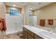 Bright bathroom with a glass-enclosed shower, double sinks, and a large mirror for ample natural light at 11627 E Bella Vista Dr, Scottsdale, AZ 85259