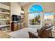 Bright living room with a large window, built-in shelving, and comfortable seating, ideal for relaxation at 11627 E Bella Vista Dr, Scottsdale, AZ 85259