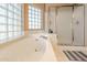 Bright bathroom with large soaking tub and frosted glass shower at 12439 W Monte Vista Rd, Avondale, AZ 85392