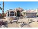 Single-story home with three car garage, desert landscaping featuring large cacti, rocks and an American flag at 12439 W Monte Vista Rd, Avondale, AZ 85392