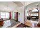 Bright living room featuring high ceilings, hardwood floors, and large windows with red curtains at 12439 W Monte Vista Rd, Avondale, AZ 85392