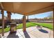 Inviting covered patio with a built-in grill and a lovely view of the well-manicured backyard at 12439 W Monte Vista Rd, Avondale, AZ 85392