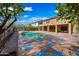 View of the backyard with pool, decorative concrete, and mature landscaping at 13569 W Ventura St, Surprise, AZ 85379