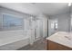 Bathroom featuring dual sinks, a glass-enclosed shower, and a soaking tub at 13569 W Ventura St, Surprise, AZ 85379