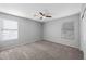 Bedroom featuring a ceiling fan, neutral walls and carpet, and windows to create a comfortable space at 13569 W Ventura St, Surprise, AZ 85379