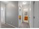 Hallway features neutral walls, carpet and light fixtures with views into a bathroom and other rooms at 13569 W Ventura St, Surprise, AZ 85379