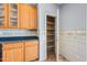 Kitchen with pantry, wood cabinets, tile backsplash and dark countertops at 13569 W Ventura St, Surprise, AZ 85379