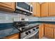 Close up of the kitchen featuring stainless steel range and microwave with tile backsplash at 13569 W Ventura St, Surprise, AZ 85379