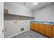 Laundry room with cabinets, shelving, blue countertops, and light grey walls offers functionality and storage at 13569 W Ventura St, Surprise, AZ 85379