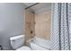 Neutral bathroom features a bathtub with tan tile surround and black and white shower curtain at 1601 E Elgin St, Chandler, AZ 85225