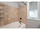 Neutral bathroom features a bathtub with tan tile surround and a window at 1601 E Elgin St, Chandler, AZ 85225