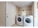 Laundry room boasts full-size washer and dryer, tiled flooring, and built-in shelving at 1601 E Elgin St, Chandler, AZ 85225