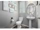 Stylish powder room featuring a pedestal sink, coastal decor, and a fresh, clean aesthetic at 16561 W Cielo Grande Ave, Surprise, AZ 85387