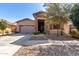 Attractive home exterior with a stone accent entrance, a two-car garage, and desert landscaping at 16561 W Cielo Grande Ave, Surprise, AZ 85387