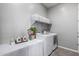 Well-lit laundry room with modern washer and dryer, ample counter space, and stylish storage baskets at 16561 W Cielo Grande Ave, Surprise, AZ 85387