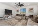 Bright living room featuring tile floors, a ceiling fan, and a window at 16846 W Molly Ln, Surprise, AZ 85387