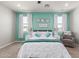 A bedroom with a teal accent wall, carpeted floors, a ceiling fan and lots of natural light at 17762 W Granite View Dr, Goodyear, AZ 85338