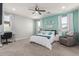 A bedroom with a teal accent wall, carpeted floors, a ceiling fan and lots of natural light at 17762 W Granite View Dr, Goodyear, AZ 85338