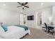 A bedroom with a mounted television and workstation with carpeted floors and neutral walls at 17762 W Granite View Dr, Goodyear, AZ 85338