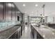 Modern kitchen with granite countertops, stainless steel appliances, and an open layout flowing into the dining area at 17762 W Granite View Dr, Goodyear, AZ 85338