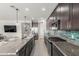 Modern kitchen featuring sleek cabinetry, granite countertops, stainless steel appliances and glass backsplash at 17762 W Granite View Dr, Goodyear, AZ 85338