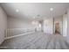 Spacious loft with carpet and railing, offering a versatile area for work or recreation at 17989 W Camino De Oro --, Surprise, AZ 85387