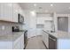 Bright kitchen features white cabinets, gray backsplash, stainless appliances, and granite countertops at 17996 W Camino De Oro --, Surprise, AZ 85387