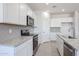 Bright kitchen features white cabinets, gray backsplash, stainless appliances, and granite countertops at 17996 W Camino De Oro --, Surprise, AZ 85387