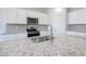 Bright kitchen features white cabinets, gray backsplash, stainless appliances, and granite countertops at 17996 W Camino De Oro --, Surprise, AZ 85387