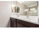 Bathroom with double sink vanity, dark wood cabinets, and a large mirror creates a functional space at 18800 W Madison St, Buckeye, AZ 85326