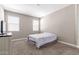 Neutral bedroom with carpet, two windows, and simple decor provides a calm and inviting space at 18800 W Madison St, Buckeye, AZ 85326