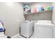 Functional laundry room equipped with a washer, dryer, and shelving for storage at 18800 W Madison St, Buckeye, AZ 85326