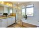 Bright bathroom featuring dual sinks, a glass-enclosed shower, and a soaking tub at 1940 W Kinfield Trl, Phoenix, AZ 85085